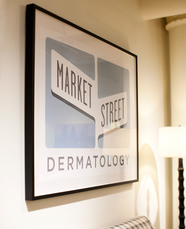 The original Market Street Dermatology sign displayed in the warmly furnished office